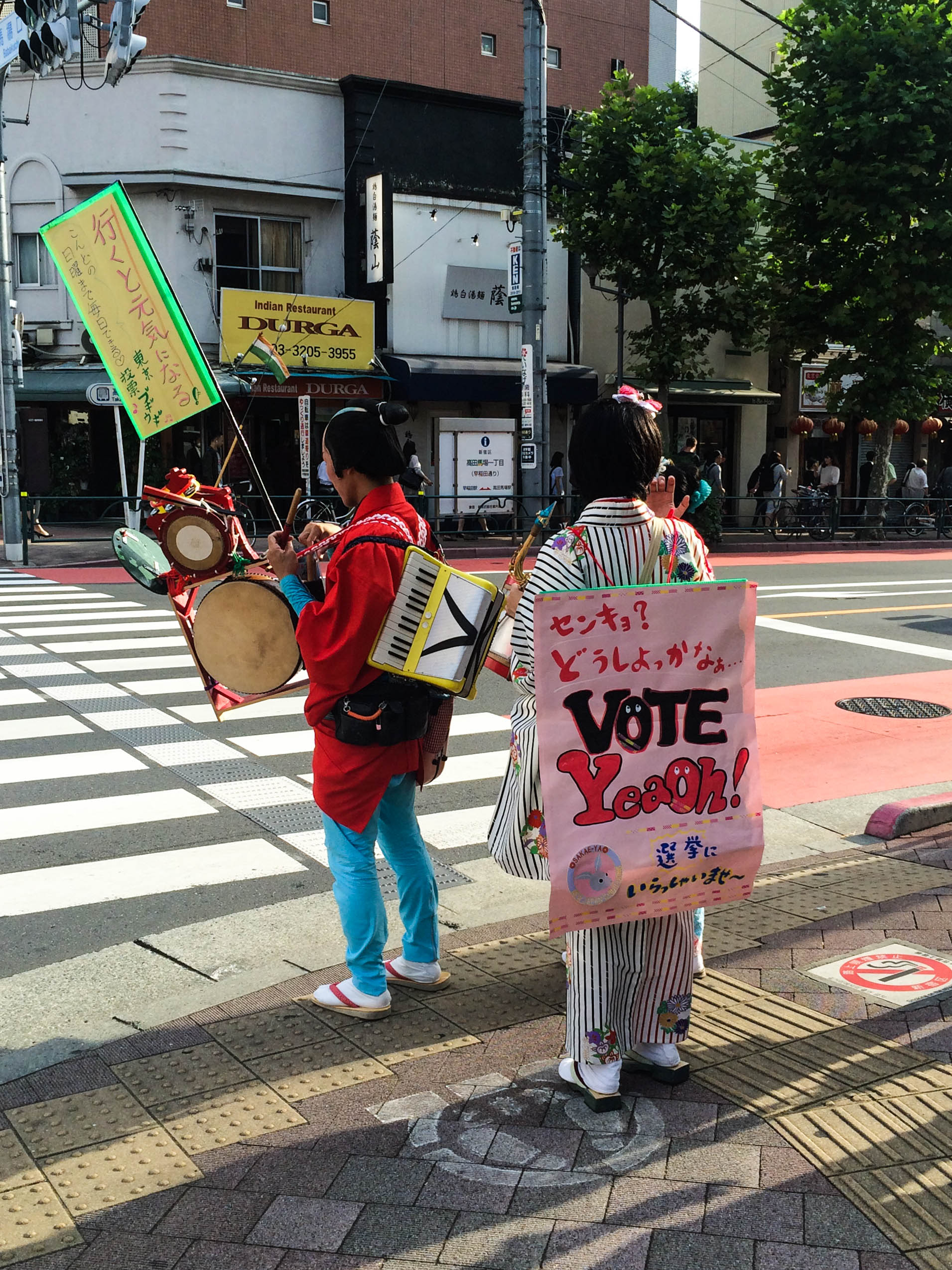 Deux etudiants faisant la promotion du vote, l'un portant une pancarte 'Vote YeaOH!'